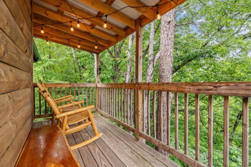 a wooden porch with a bench and a chair on it at Moonlit Pines by American Patriot Getaways in Oldham