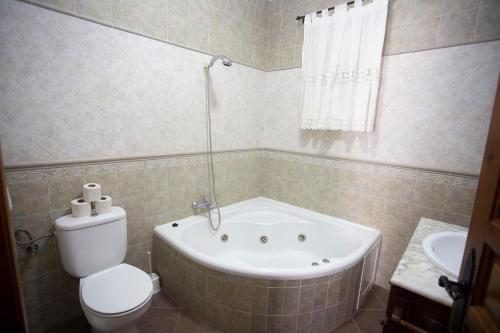 a bathroom with a tub and a toilet and a sink at Viviendas Turísticas El Mero in Zahora