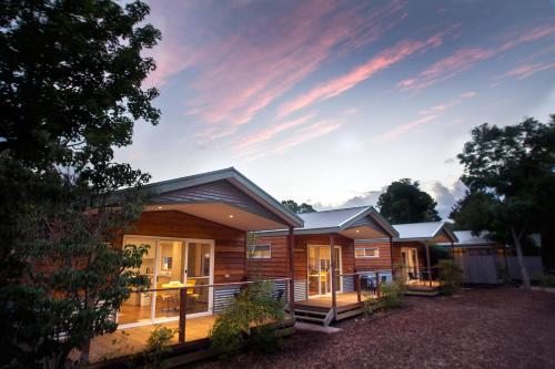 um grupo de chalés com o pôr-do-sol ao fundo em BIG4 Tasman Holiday Parks - Bright em Bright