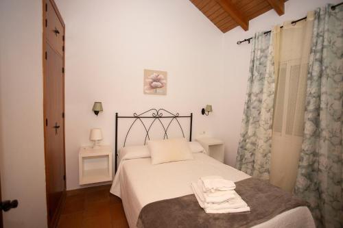 a bedroom with a bed with two towels on it at Viviendas Turísticas El Mero in Zahora
