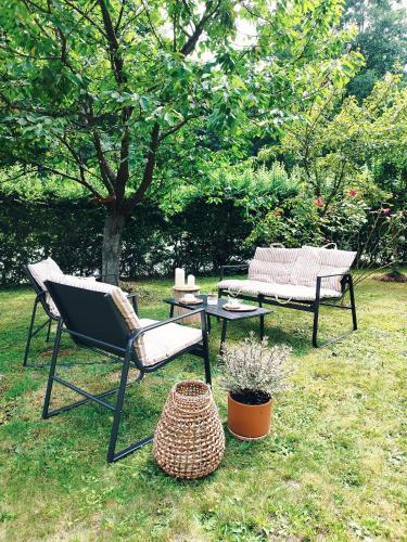two chairs and a table and a bench in the grass at Schupplerova vila in Hoštejn