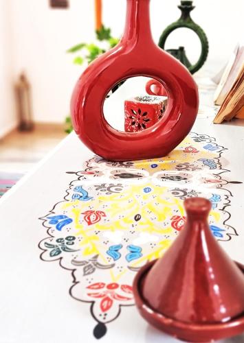 a red vase sitting on top of a table at Villa des étoiles Groupes in Ourika