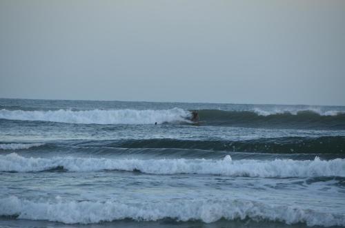 a surfer riding the waves in the ocean at La Brújula Hostel in La Paloma