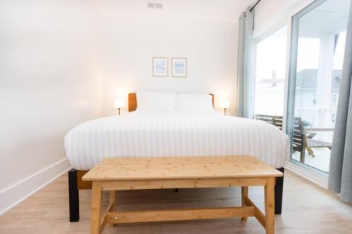 a bedroom with a bed and a wooden table at 3 BDR Renovated Condo The Beach1 block in Wildwood