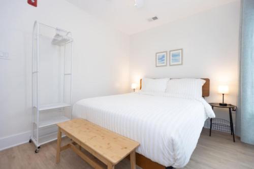 a bedroom with a white bed and a wooden table at 3 BDR Renovated Condo The Beach1 block in Wildwood