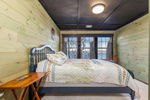 a bedroom with a bed and a wooden wall at Gilead Grand Lake Family Retreat in Grove