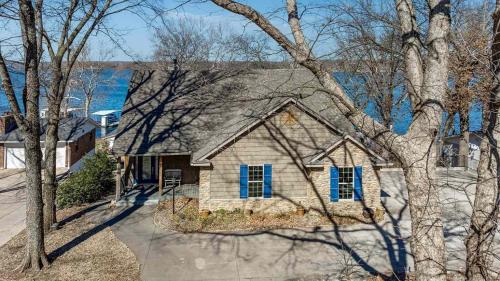 a house with blue shuttered windows and a tree at Gilead Grand Lake Family Retreat in Grove