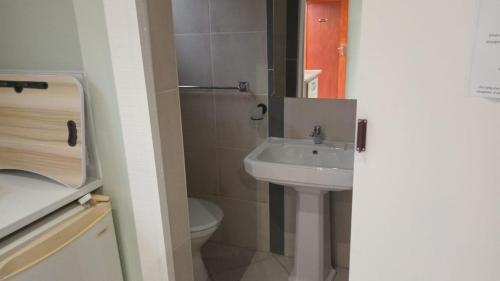 a bathroom with a sink and a toilet at Emampingeni lodge in Bizana