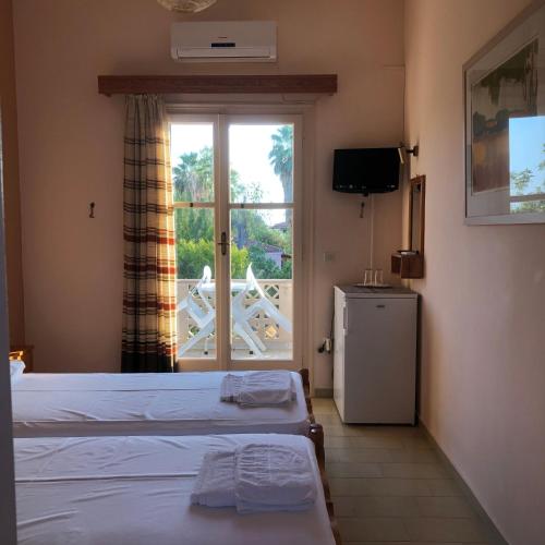 a hotel room with two beds and a window at Guesthouse Karidia in Skala Eresou