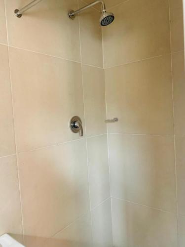 a shower with a glass door with a shower head at Emampingeni lodge in Bizana