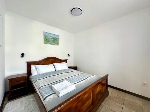 a bedroom with a wooden bed with two towels on it at Apart-hotel Villa Lav in Tivat