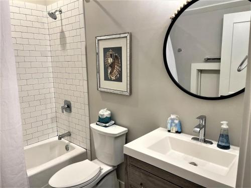 Un baño con lavabo, inodoro y espejo. en 50 Stock Farm Rd - Charming Old Town Bluffton, en Bluffton