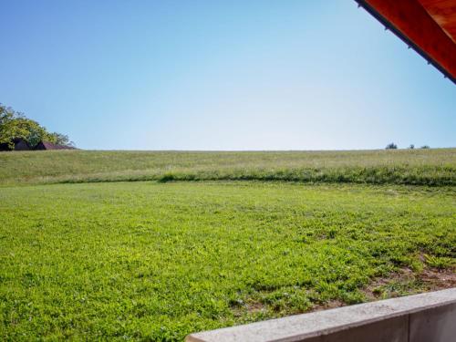 a field of green grass with a red roof at Ferienwohnung am Gleichenberger "Kogl" in Bad Gleichenberg