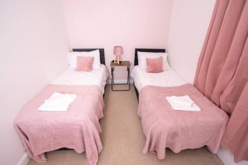 two twin beds in a room with pink blankets at Newly Renovated Sanctuary for 4 in Charlotte House in Ipswich