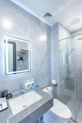 a bathroom with a toilet and a sink and a shower at LUMI West Lake Hotel in Hanoi