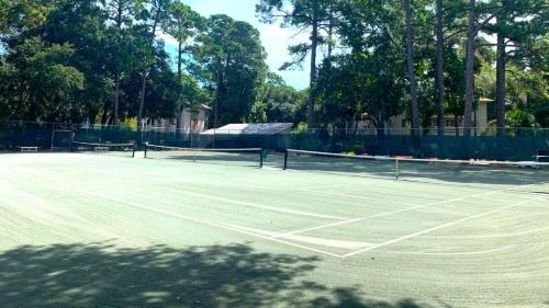 a tennis court with two tennis rackets on it at Fiddler's Cove 11e - Updated Folly Field Villa in Hilton Head Island