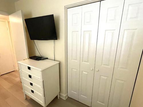 a bedroom with a white closet with a television on a dresser at Fiddler's Cove 11e - Updated Folly Field Villa in Hilton Head Island