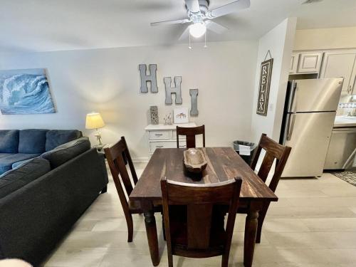 a kitchen and dining room with a table and a couch at Fiddler's Cove 11e - Updated Folly Field Villa in Hilton Head Island