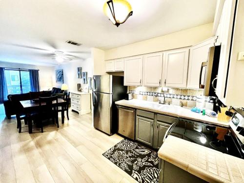a kitchen and dining room with a table and refrigerator at Fiddler's Cove 11e - Updated Folly Field Villa in Hilton Head Island
