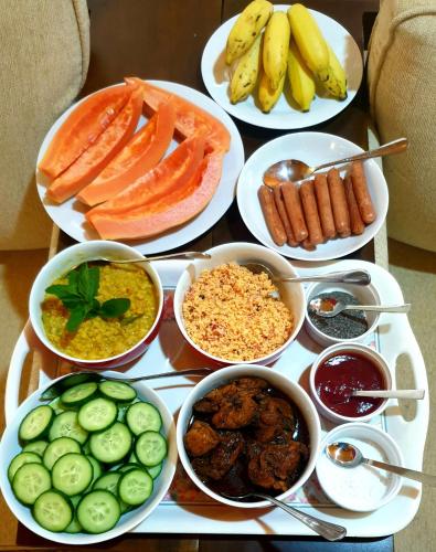 a table topped with plates of different types of food at Tea sprig villa in Boralanda