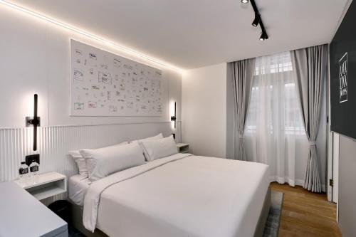 a white bedroom with a white bed and a window at Casa Guogu by AmazINN Places 2f in Panama City
