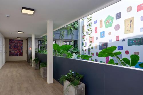 an office corridor with plants on the wall at Casa Guogu by AmazINN Places 2f in Panama City