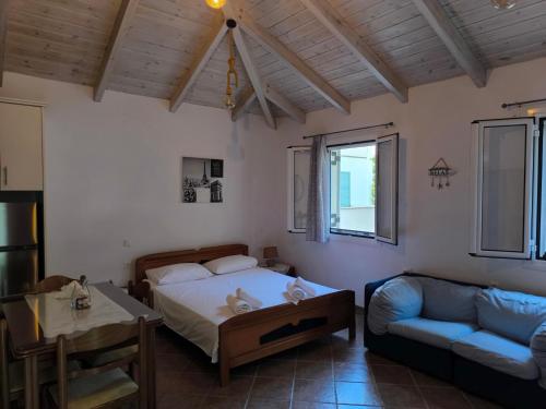 a bedroom with a bed and a couch at Sofias house at Agkona Kefalonia in Angón