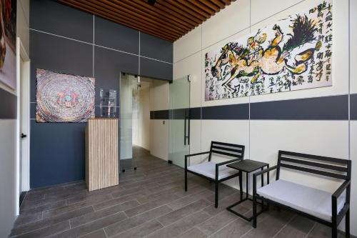 a room with two chairs and a painting on the wall at Casa Guogu by AmazINN Places 3f in Panama City