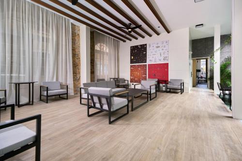 a waiting area with chairs and tables in a building at Casa Guogu by AmazINN Places 3f in Panama City