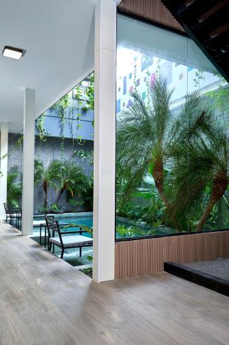 a lobby with a palm tree in a building at Casa Guogu by AmazINN Places 3f in Panama City