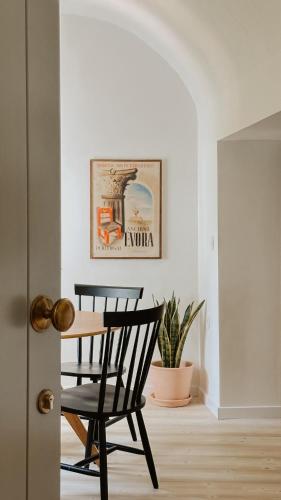 a black chair and a table in a room at Casa do Miradouro in Évora