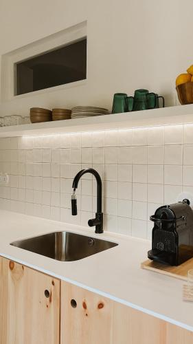 een keuken met een wastafel en een plank met borden bij Casa do Miradouro in Évora