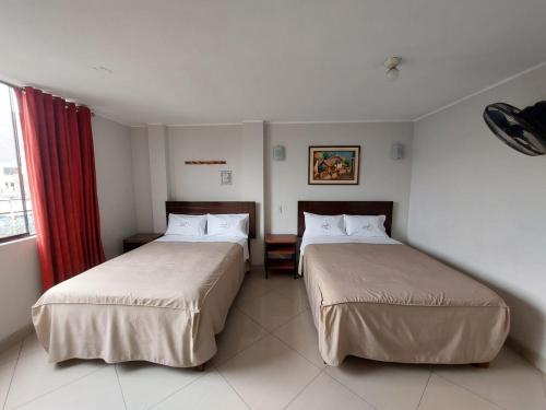 ein Hotelzimmer mit zwei Betten und einem Fenster in der Unterkunft Hospedaje El Jardín in Lima