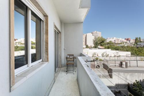 a balcony with chairs and a view of a city at GuestReady - Striking flat in Benfica in Lisbon