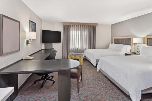 a hotel room with two beds and a desk at Candlewood Suites Appleton by IHG in Appleton