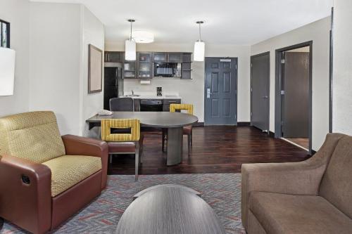 a living room and kitchen with a table and chairs at Candlewood Suites Appleton by IHG in Appleton