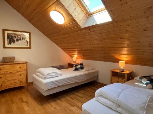 een zolderkamer met twee bedden en een dakraam bij NEW Chalet Le Sabot 12p - Sauna - 90m telecabine in Oz