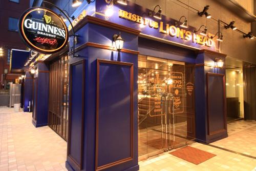 a store front with a blue wall and a sign at Hotel Sunshine Utsunomiya in Utsunomiya