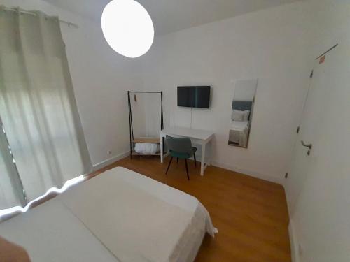 a bedroom with a bed and a table and a mirror at Martins' Happy Home in Coimbra