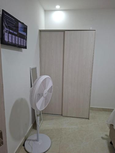 a white fan in a room with a closet at Perla del río habitaciones in Barranquilla
