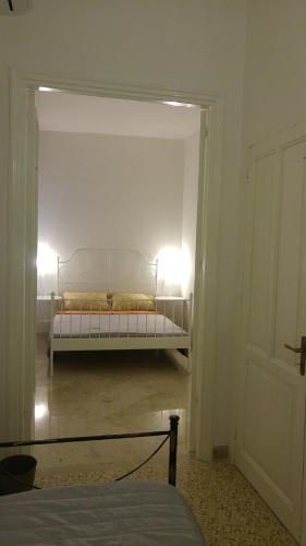 a bedroom with a bed in a white room at Appartamenti al Porto in Trapani