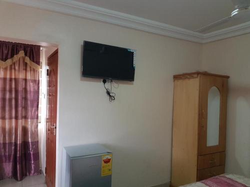 a bedroom with a flat screen tv on the wall at Crystal Rock Hotel in Teiman