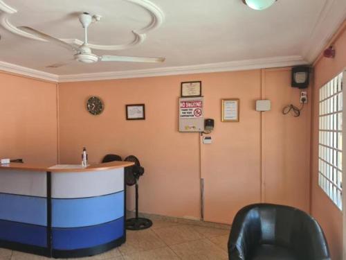 a waiting room with a counter and a room with aublic at Crystal Rock Hotel in Teiman
