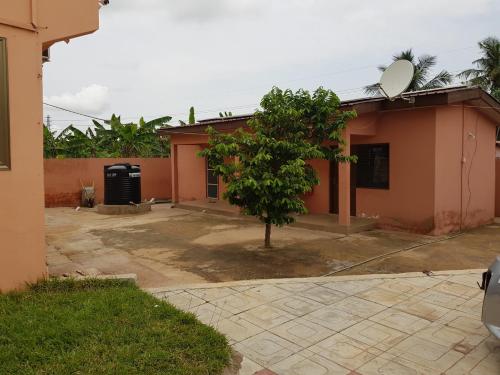 a house with a tree in front of it at Crystal Rock Hotel in Teiman