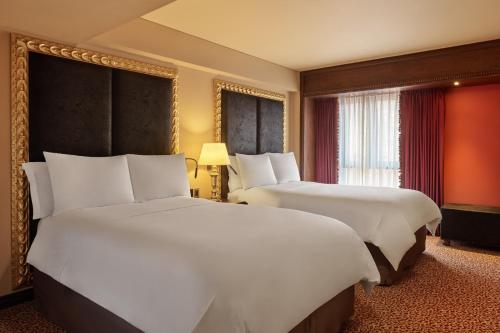 a hotel room with two beds and a window at Palacio del Inka, a Luxury Collection Hotel, Cusco in Cusco