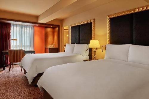 a hotel room with two beds and a window at Palacio del Inka, a Luxury Collection Hotel, Cusco in Cusco