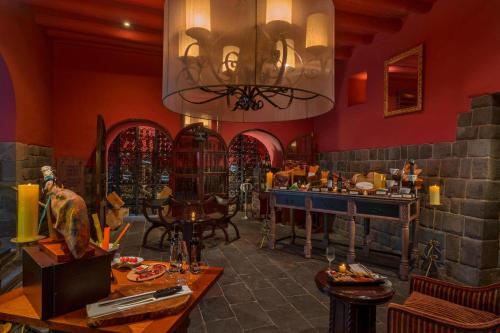 a dining room with red walls and a chandelier at Palacio del Inka, a Luxury Collection Hotel, Cusco in Cusco