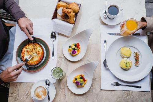 a table topped with plates of food and drinks at Palacio del Inka, a Luxury Collection Hotel, Cusco in Cusco