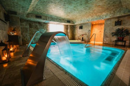 a swimming pool with a water slide in a building at Palacio del Inka, a Luxury Collection Hotel, Cusco in Cusco