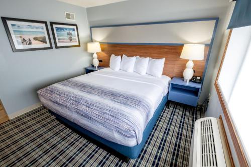 a hotel room with a large bed and two lamps at AmericInn by Wyndham Sturgeon Bay in Sturgeon Bay